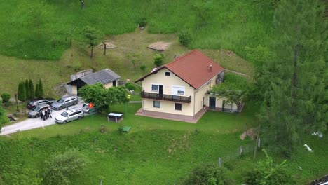 vista aérea de la casa familiar con autos estacionados entre naturaleza verde idílica