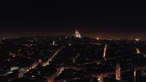 paris city at night view from the distance over basilica montmartre