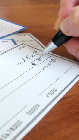 writing a check for payment with a ballpoint pen