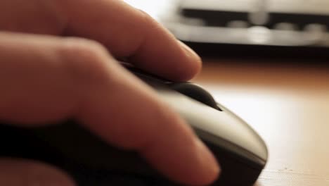 Close-up-of-a-hand-operating-a-computer-mouse-on-a-wooden-desk