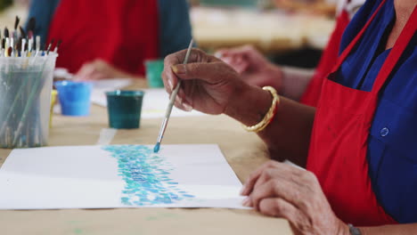 un primer plano de una mujer que asiste a una clase de arte en un centro comunitario.
