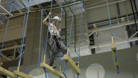 child navigating an indoor ropes course