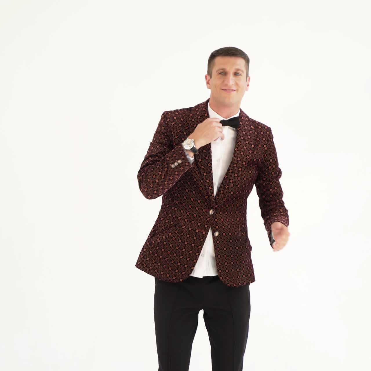 humorist in dark suit is parodying the body movements of a dancing person at a party