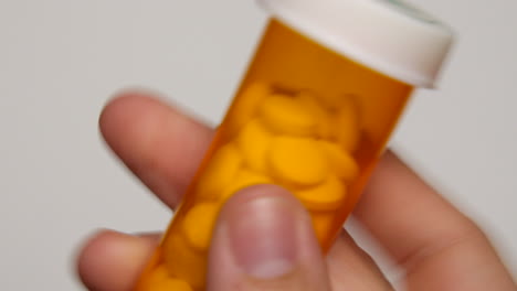 person puts cap back onto pill bottle