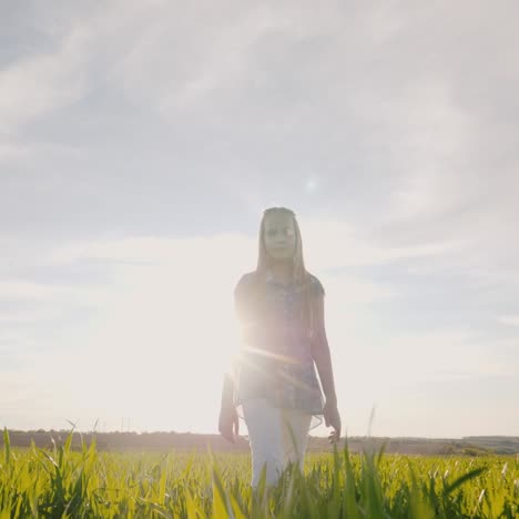 chica pensativa camina por un prado verde