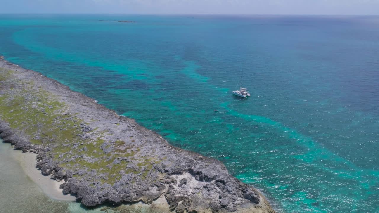 vista aérea de la isla desierta de las bahamas con un velero solitario y buceadores