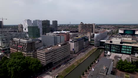 Aerial-pan-showing-financial-district-and-central-train-station-area-with-modern-architecture-and-historic-office-buildings-in-city-center-of-Dutch-urban-Utrecht-in-The-Netherlands