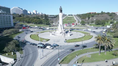 Eine-Geschäftige-Verkehrsszene-Umgibt-Die-Berühmte-Marques-de-Pombal-Statue-In-Lissabon,-Und-Der-Weitläufige-Eduardo-VII-Park-Bietet-Eine-Friedliche-Erholung-Von-Der-Hektik-Der-Stadt