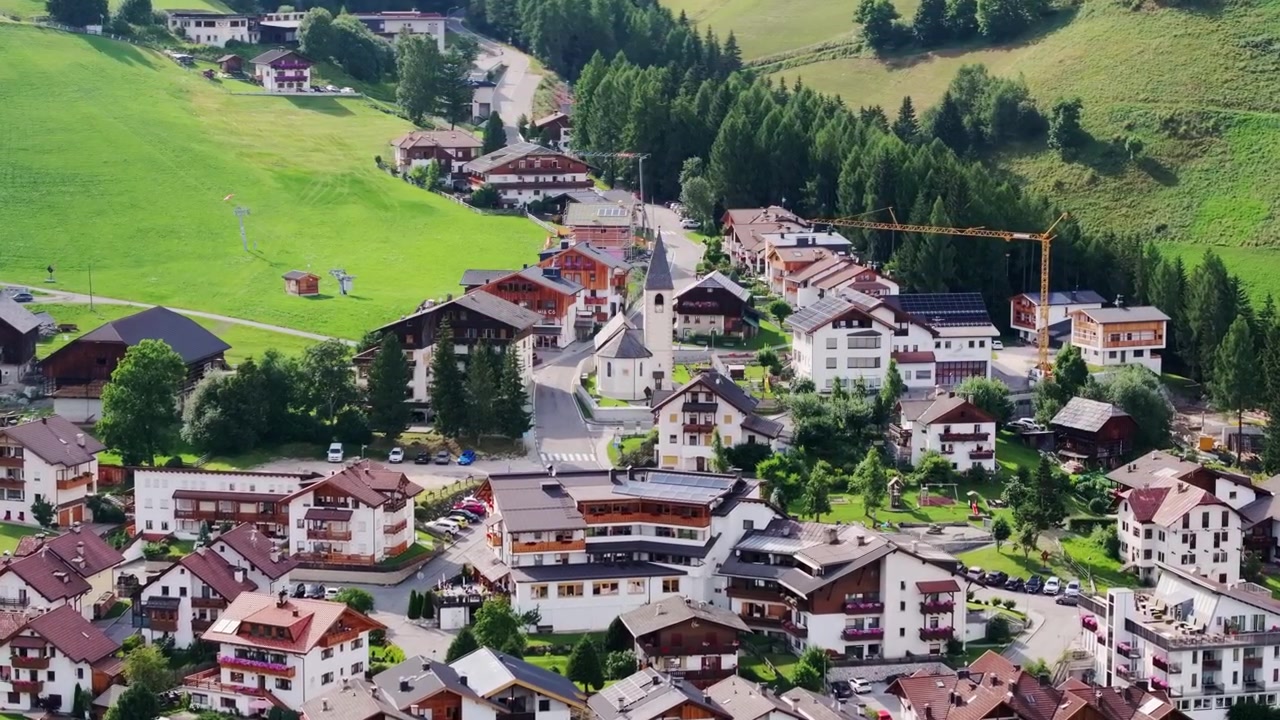 Dorf Antermoia, Italien – Üppig grüne Hügel, Baukran, Symbol des Wachstums.