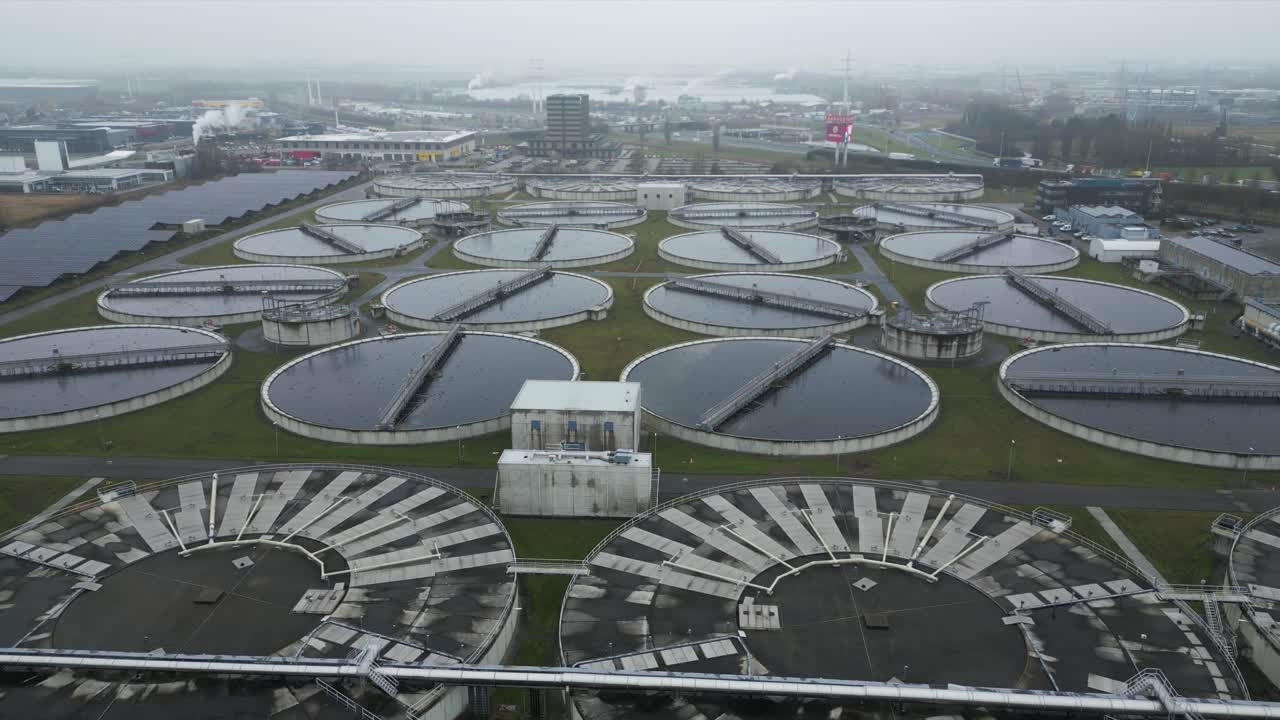 Symmetrical drone view showing circular wastewater basins and processing infrastructure at Harnaschpolder wastewater treatment plant in the Netherlands