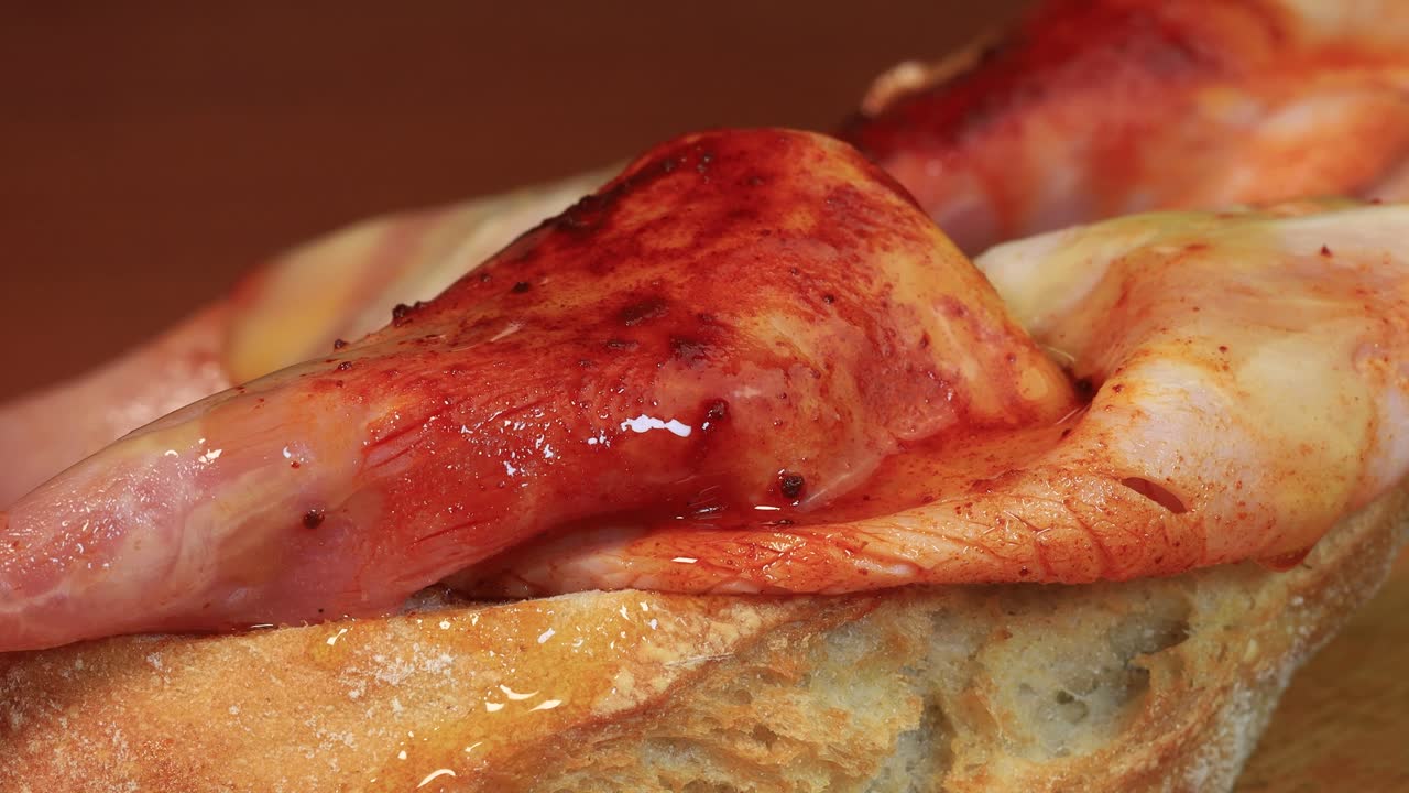 빵 한 조각 위에 양념한 햄 위에 올리브 오일을 붓고 4k의 매크로 샷