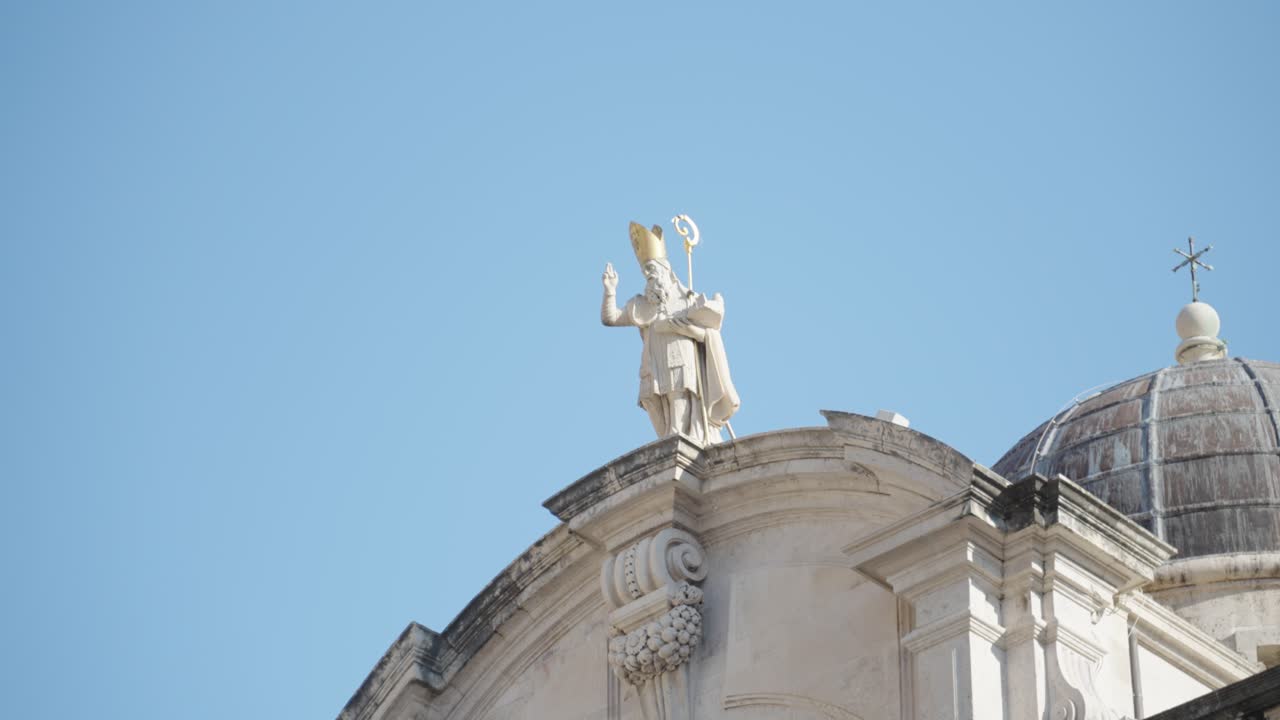 Clos up of the statue of St. Blasius holidng a rod on top of his Church with the same name in Old Town Dubrovnik Croatia with a clear blue sky in the summer