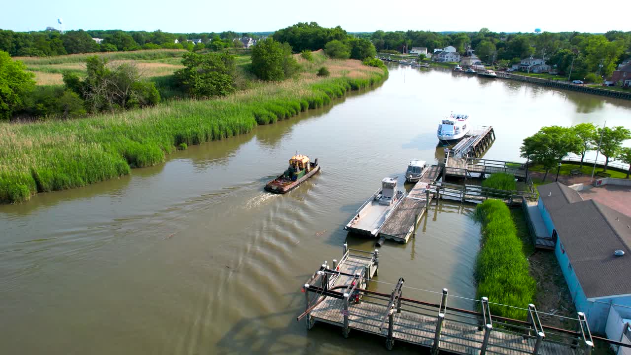Small boat returns to harbor marina early summer delaware from drone.