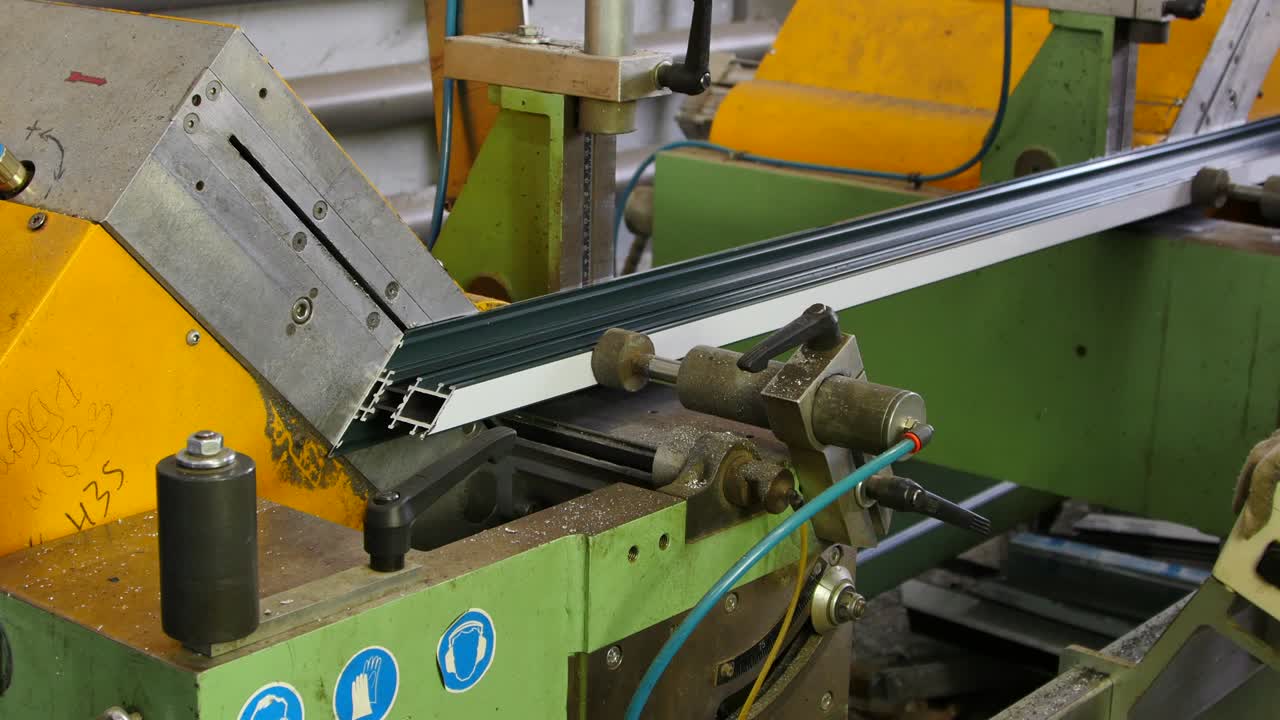 노동자 손은 공장에서 기계에 원형 도자기로 알루미 프로파일을 잘라.