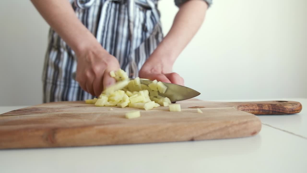 mujer cortando patatas en una tabla de madera