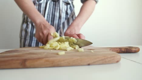 woman chopping potato on wooden board