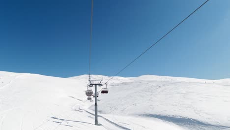 Beautiful-winter-landscape,-shot-from-a-chairlift,-in-a-clear-blue-sky-day-and-a-perfect-white-slope