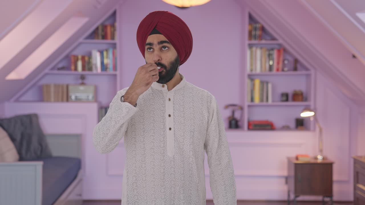 Uomo indiano Sikh malato che misura la febbre con il termometro