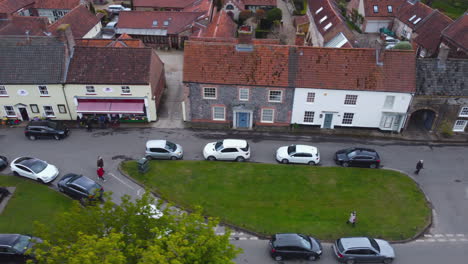 sideways slider aerial drone shot of beautiful old village burnham market shops and houses on sunny and cloudy day north norfolk uk