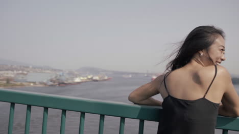 plano medio de una hermosa mujer asiática haciendo una cara sonriente graciosa en el puente lions gate en vancouver, cámara lenta