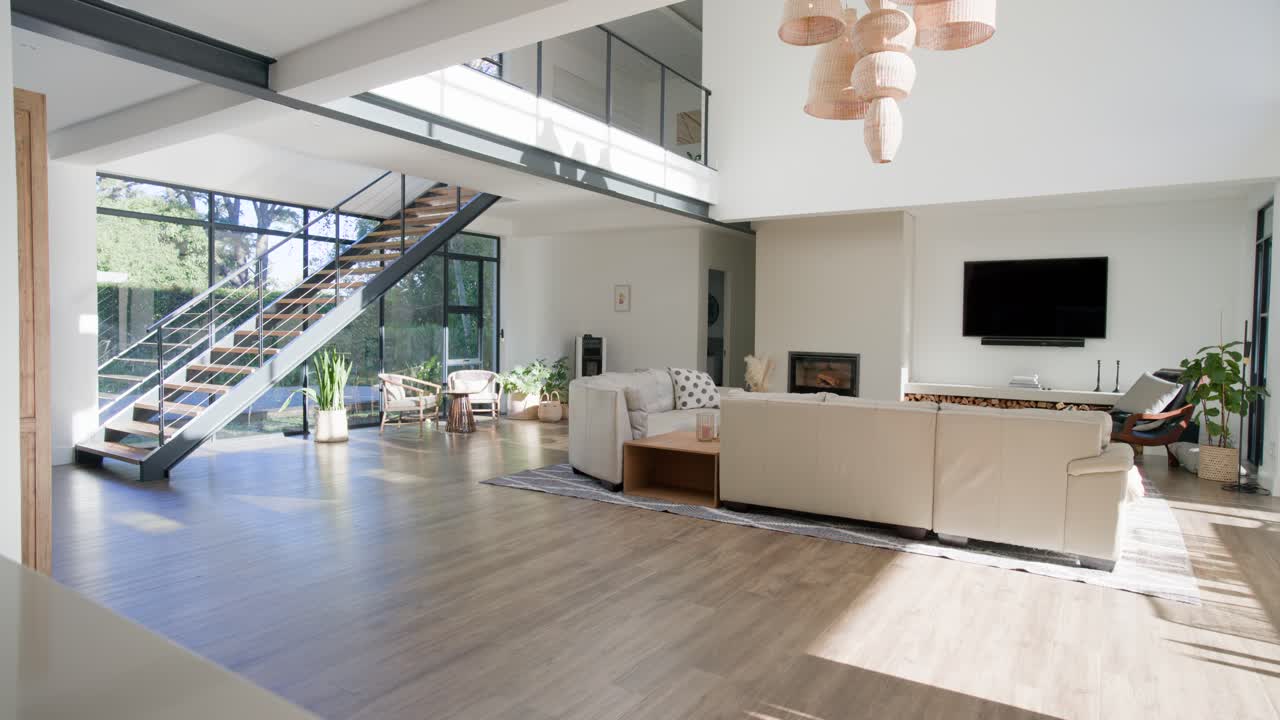 Sunlight is moving through windows lighting beige sofa and rug in living room as sun shifts