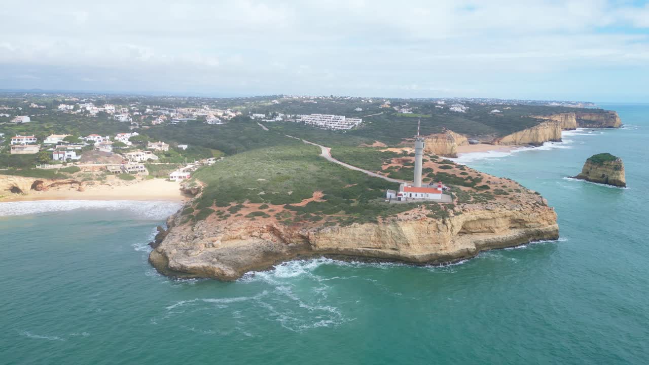 Coastal view of Ferragudo Algarve with lighthouse on rocky cliff, aerial summer shot