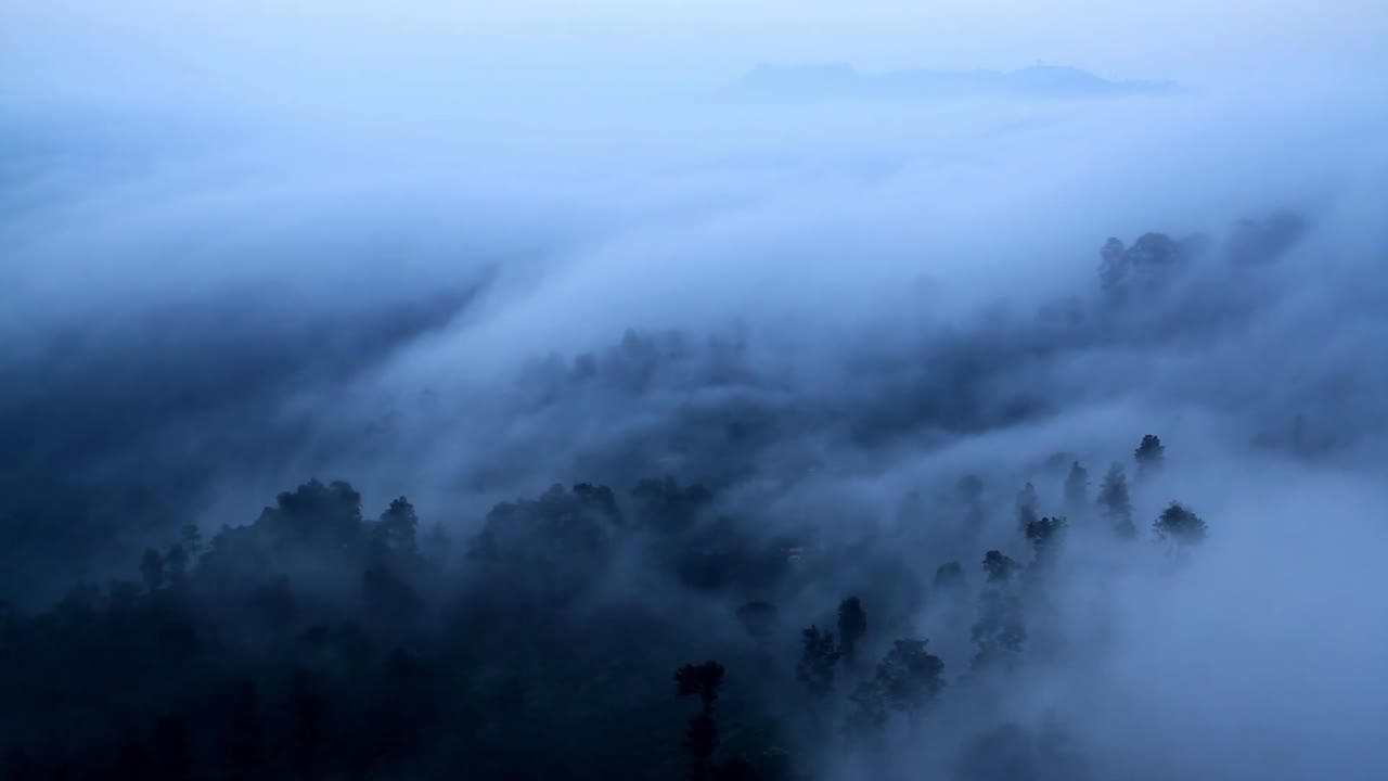 Misty Fog Blowing Over Mountain Stock Footage captures a dramatic and atmospheric mountain landscape as thick mist and fog move gracefully across rugged peaks and slopes