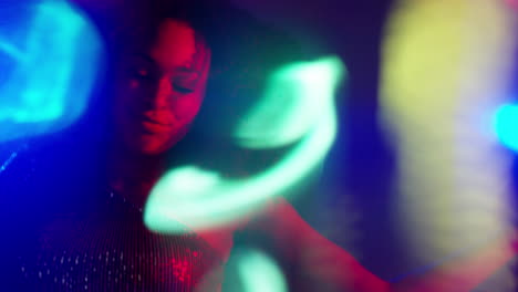 close up of young woman in nightclub bar or disco dancing with sparkling lights 3