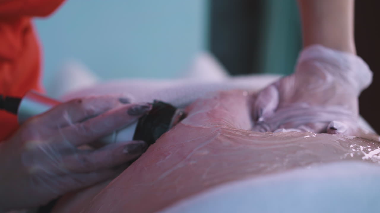 un cosmetologo fa una procedura di vibromassaggio a una donna grande