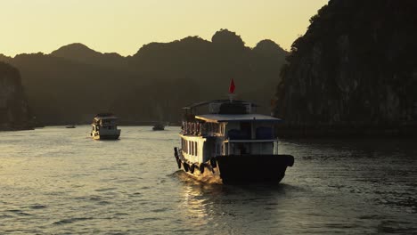 Serene-golden-morning-sunlight-on-tour-boat-motoring-on-Ha-Long-Bay