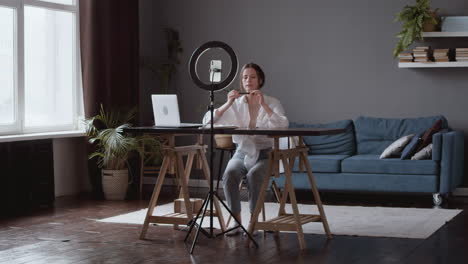 wide shot of a vlogger woman making a video review of make up and cosmetic products