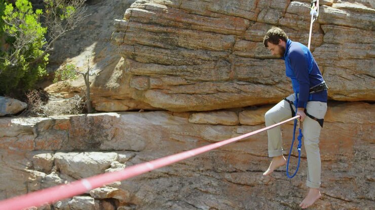 Mountaineer trying to get on the rope for tightrope walking 4k