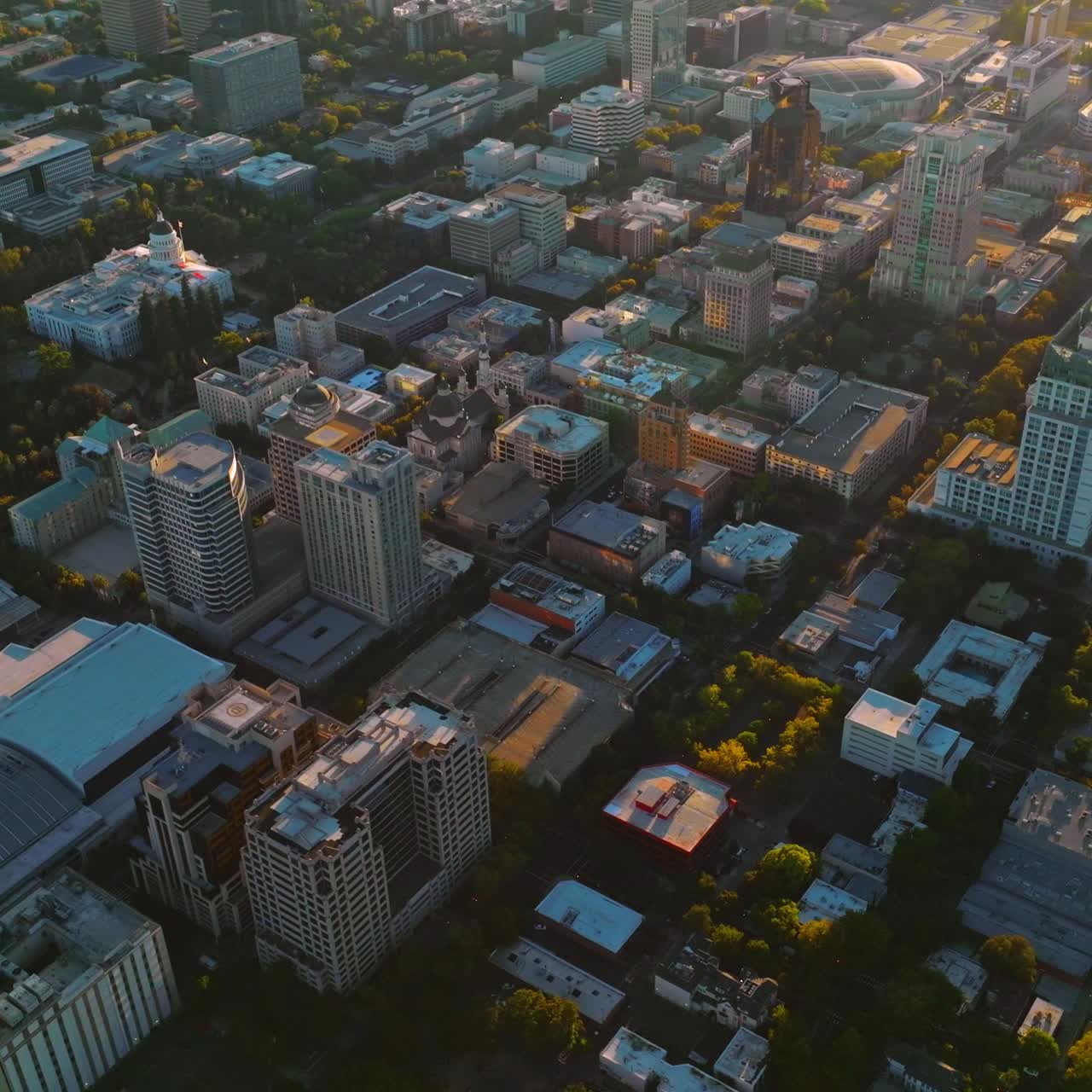 Densely built architecture of beautiful Sacramento in the rays of sun. Drone footage over the city at daytime