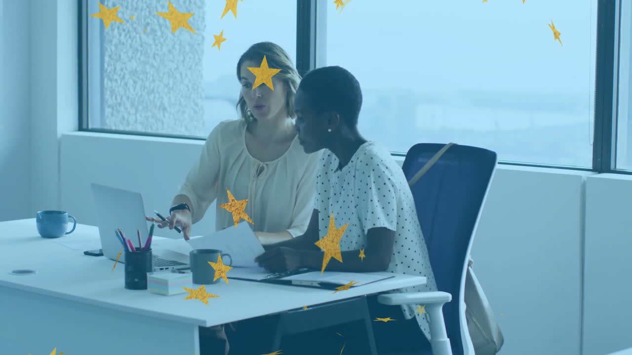 Due donne che discutono documenti alla scrivania, con un'animazione di stelle in sovrapposizione