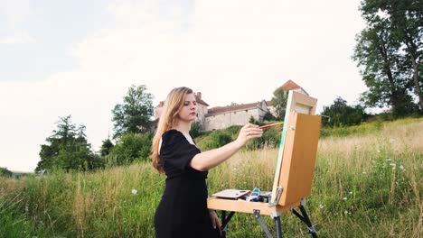 at sunlight young artist painting with oil paint picture on canvas hold brush and palette in light - at sunlight young artist painting with oil paint picture on canvas hold brush and palette in light art studio. workspace. creative