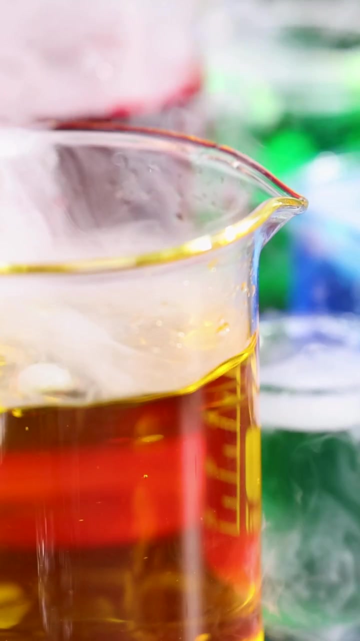 Becher con liquidi colorati e reazione con ghiaccio secco