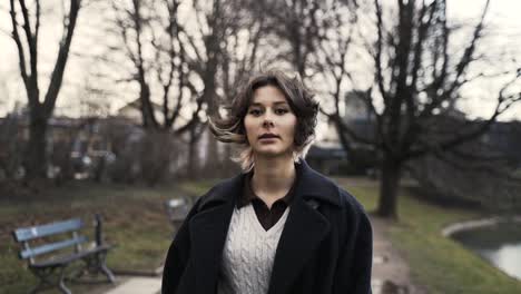 young woman in a black coat walking in a park in autumn in afternoon-1