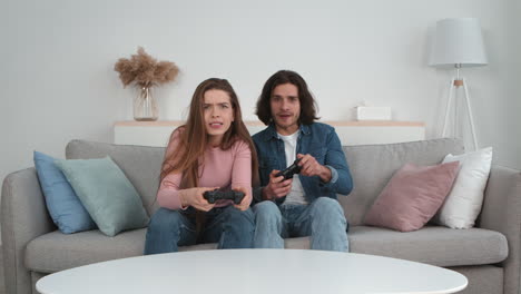 couple playing video games on a sofa