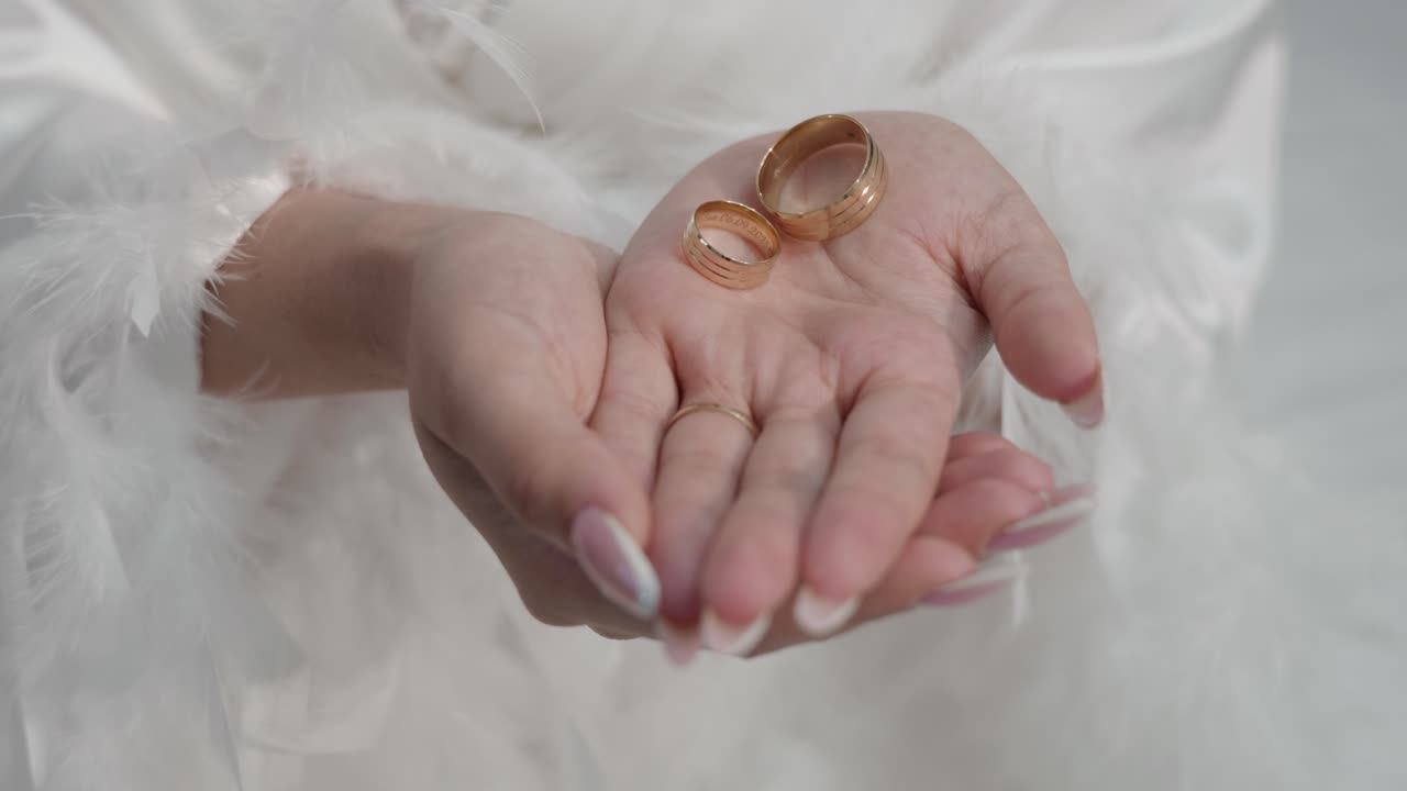 Close up shot of bride's hands while holding marriage rings