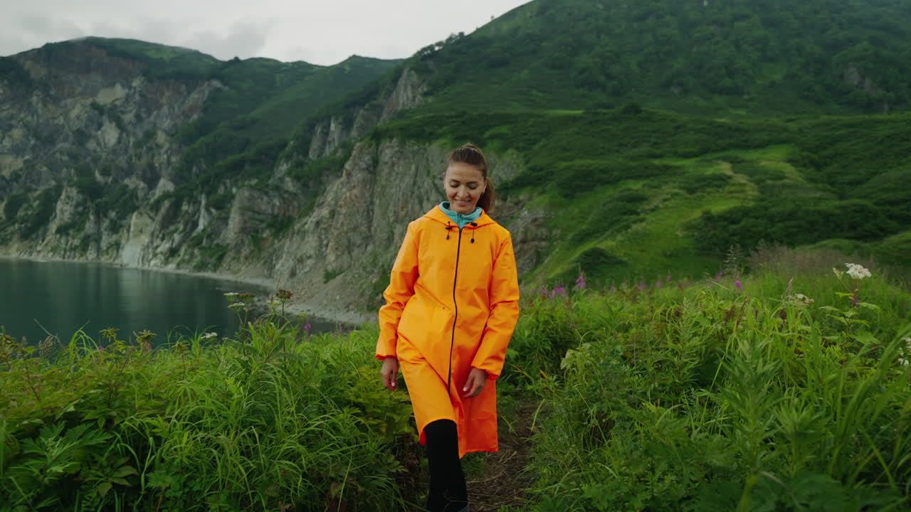 Woman Hiking in a Raincoat on a Coastal Trail
