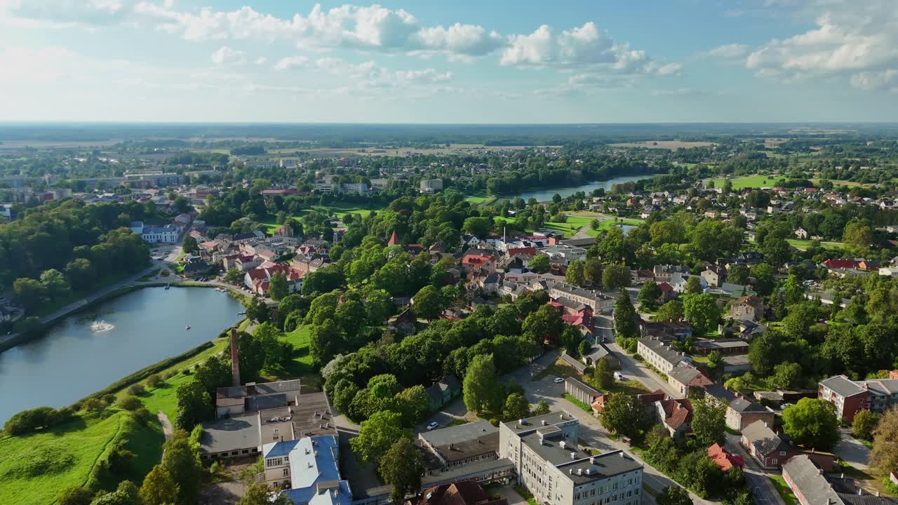 Luftfoto av Talsi, Latvia, sentrum som viser bygninger, innsjø, elv og det omkringliggende landskapet på en solrik sommerdag, som gir en pittoresk utsikt over denne sjarmerende byen