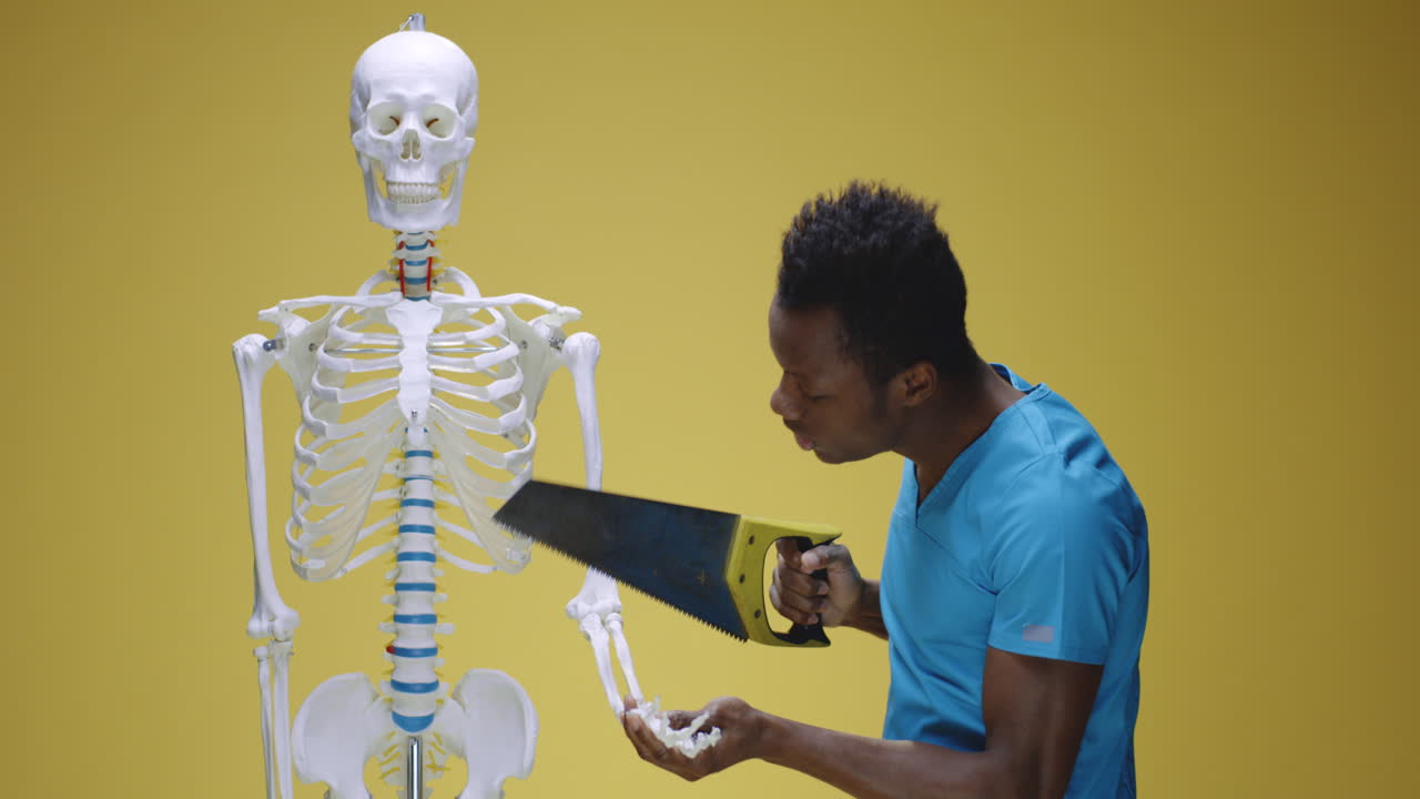 Man with saw comically interacts with human skeleton model