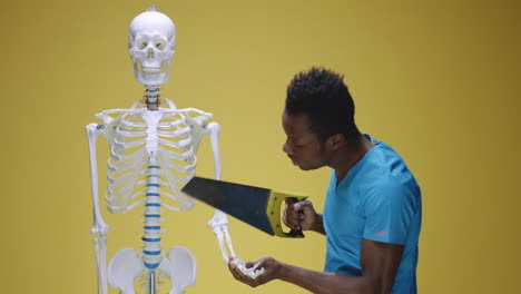 man with saw comically interacts with human skeleton model