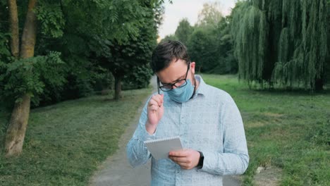 Focused-man-in-a-mask-writes-in-a-notebook