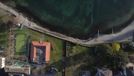 Top-down-aerial-view-of-walking-path-along-the-Lake-Geneva-waterfront-in-Lutry,-Switzerland