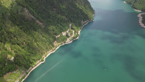 Bird-eye-View-of-rocky-mountains-on-lake-Klöntalersee-Glarus-Canton,-Switzerland