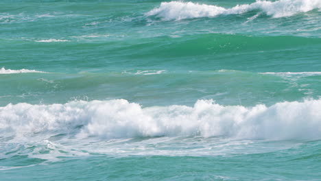 emerald sea waves forming and breaking creating white foam while rolling on sunny day in tropics