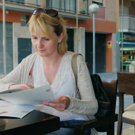 a young woman reads the menu in a cafe sits at a table by the window