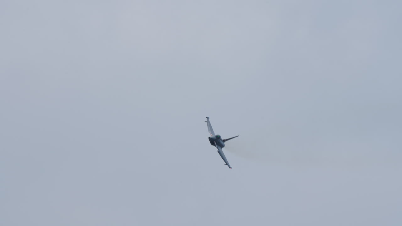Military jet aircraft flying directly toward the camera with visible front view and cloudy sky in the background
