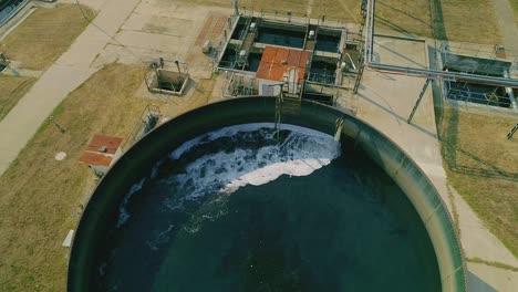 drone footage of a large circular filtration tank at a modern industrial water treatment facility